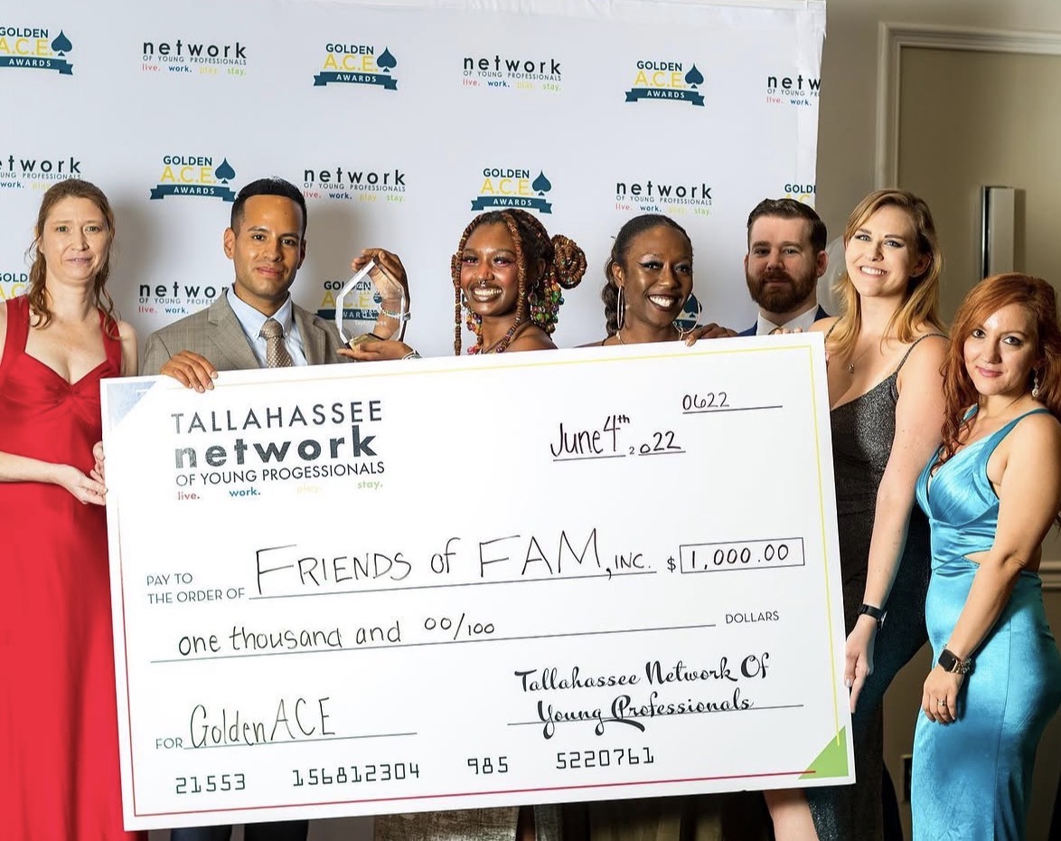 Andrew Goldstein at the Tallahassee Network of Young Professionals Golden ACE Awards, holding an award beside a $1,000 cheque for Friends of FAM